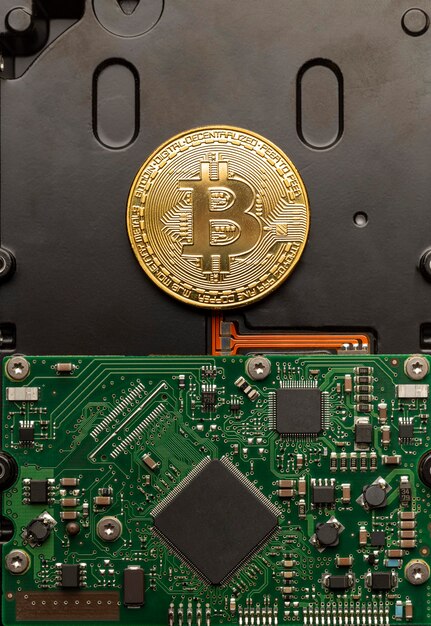 Bitcoin physique au-dessus d'un circuit imprimé, concept de monnaie numérique moderne.