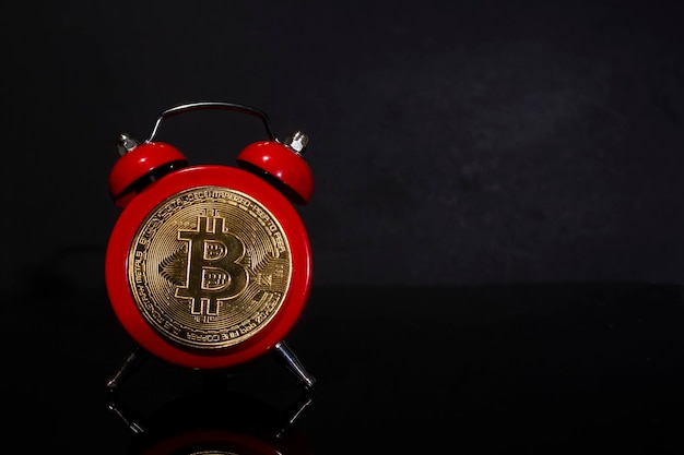 Bitcoin et réveil sur fond noir Concept de date limite pour investir dans la crypto-monnaie bitcoin