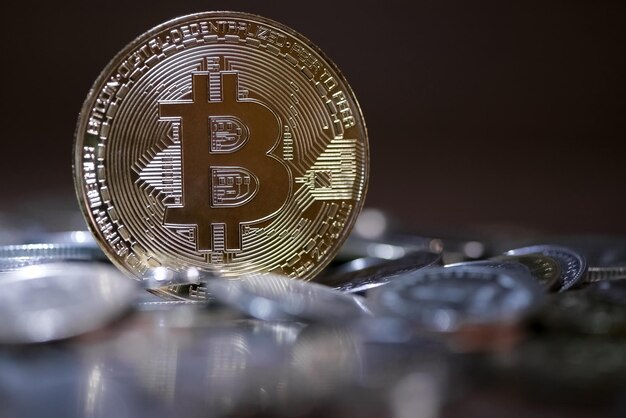 Bitcoin symbolique sur fond de pièces de monnaie dispersées floues