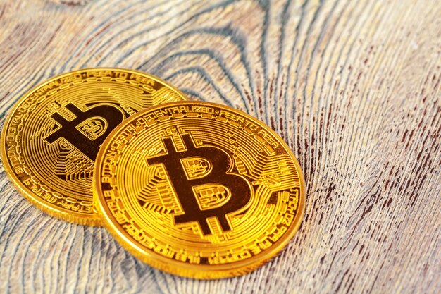 Bitcoins dorés sur une table en bois.