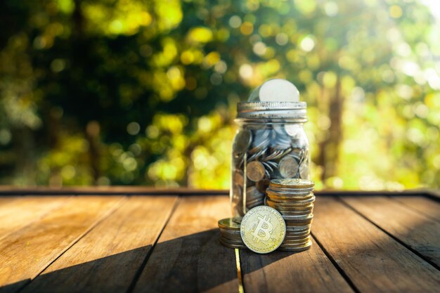 Photo bitcoins d'or placés sur une table en bois avec un fond vert naturel