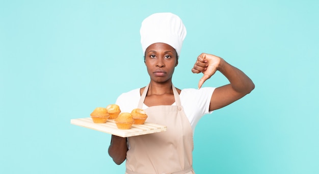 black african american adult chef woman holding a muffins tray