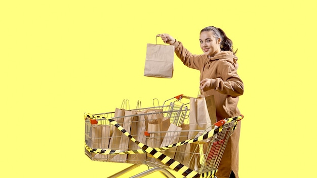 Black Friday, une fille surprise tient des sacs à provisions tout en se tenant à côté des chariots de supermarché