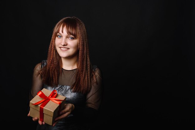 Black Friday Une jeune femme tient dans ses mains un cadeau du Nouvel An, de Noël ou de la Saint-Valentin