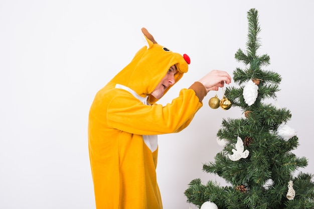 Blague, Noël, concept de personnes - homme en costume de cerf décoration arbre de Noël sur fond blanc.