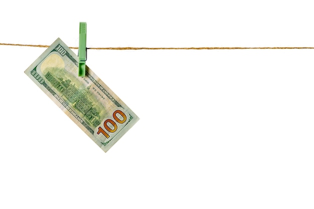 Le blanchiment d'argent des billets en dollars suspendu à une corde à linge isolé sur fond blanc