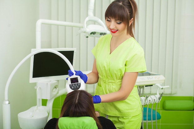 Blanchiment des dents dans une clinique dentaire pour une jolie patiente.