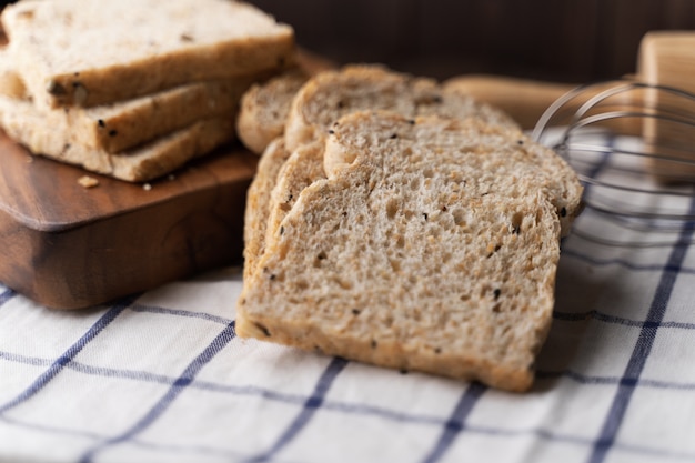 Blé entier, pain de grains entiers sur une planche en bois foncée, gros plan, vue de dessus