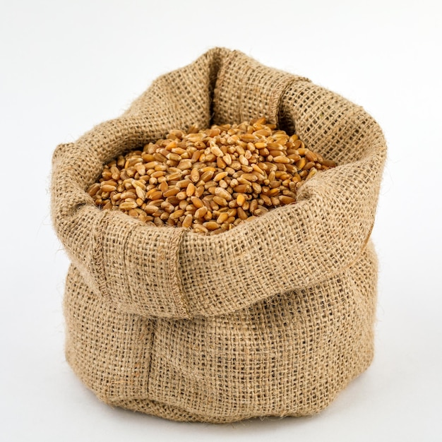 Photo blé-grain dans un sac en toile de jute isolé sur fond blanc