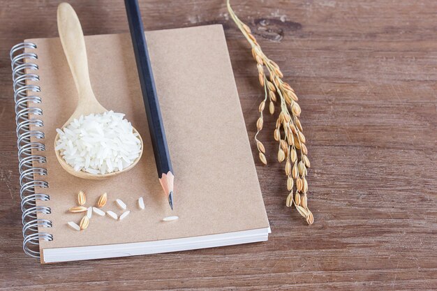 Blé et riz sur cahier avec crayon sur table en bois avec espace de copie pour la conception