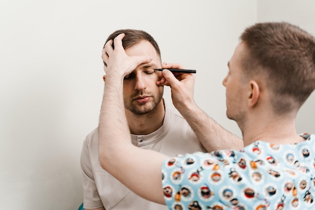 Blépharoplastie pour l'homme balisage sur le visage avant l'opération de chirurgie plastique pour modifier la région oculaire en clinique médicale