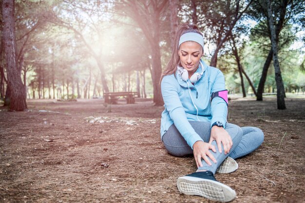 Blessure au genou de sport de coureur. Femme souffrant en courant dans le parc.