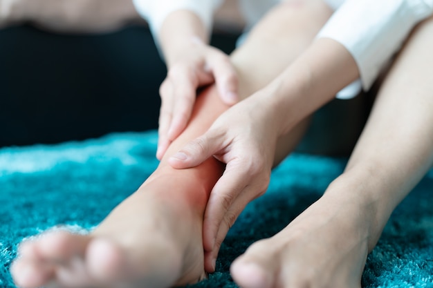 Photo blessure à la cheville de la femme / douloureuse, les femmes touchent la jambe à la douleur