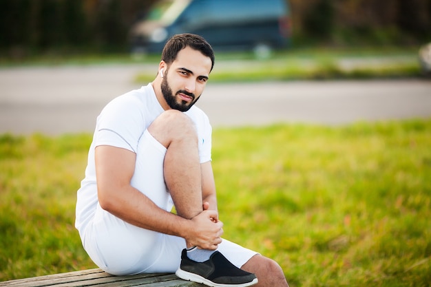 Blessure de jambe. Athlète masculin souffrant de douleurs dans la jambe lors de l'exercice à l'extérieur.