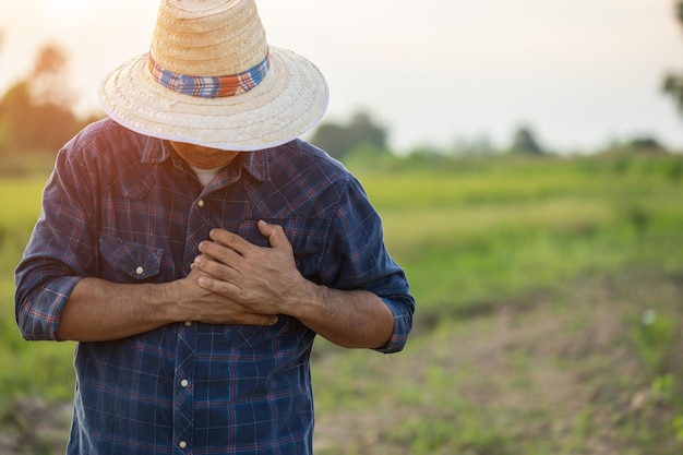 Blessures ou maladies pouvant survenir aux agriculteurs pendant le travail L'homme utilise sa main pour couvrir la poitrine gauche à cause d'une douleur ou d'un malaise