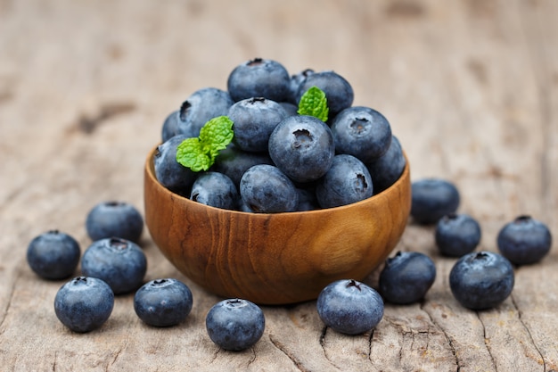 Bleuets dans un bol en bois sur une table en bois, concept de la saine alimentation et de la nutrition