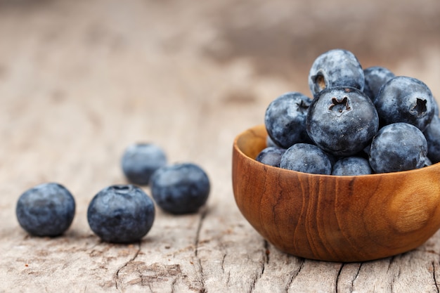 Bleuets dans un bol en bois sur une table en bois, concept de la saine alimentation et de la nutrition