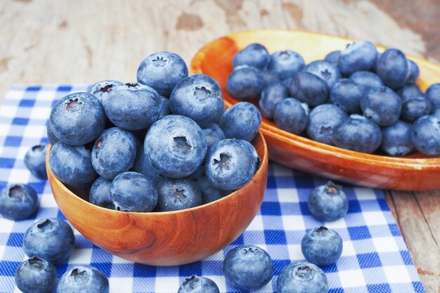 Bleuets dans des bols en bois sur une table en bois