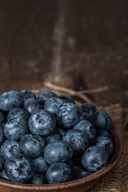 Bleuets dans des bols en céramique marron placés sur des sacs et une table en bois