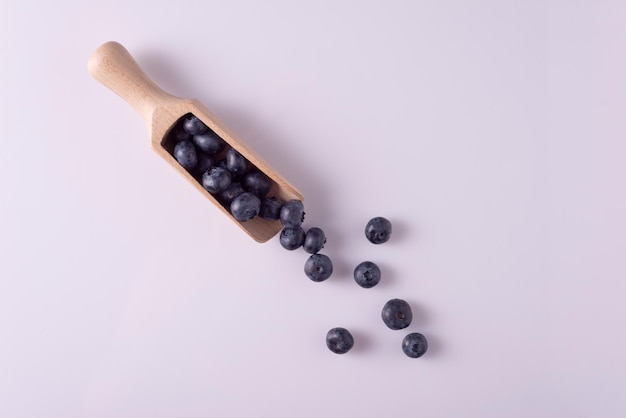 Bleuets dans une cuillère en bois sur un tableau blanc