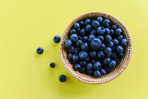 Bleuets dans un panier sur fond jaune