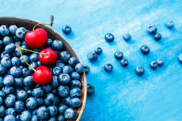 Bleuets sur fond bleu coloré. Peut être utilisé pour la myrtille, le bleu, la couleur, le coloré, la vitamine, la nutrition, les fruits, les baies, l'antioxydant, l'été, le plaisir, les thèmes alimentaires