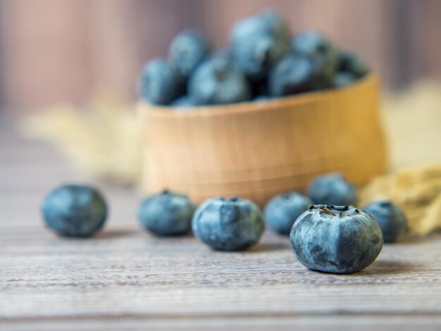 Bleuets fraîchement cueillis dans un bol en bois sur un fond en bois. Alimentation saine et nutrition. Place pour le texte.