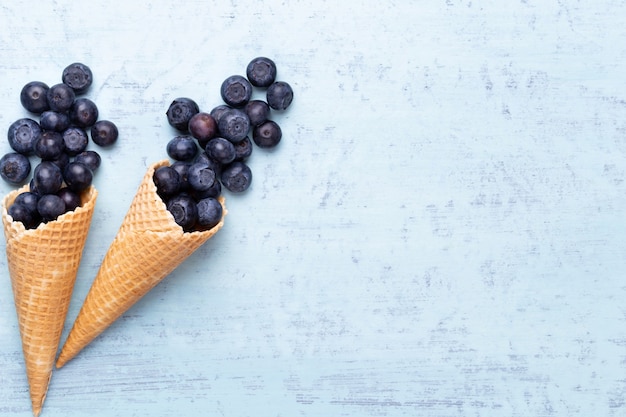 Bleuets frais, dans un bol en forme de coeur sur un fond en bois.