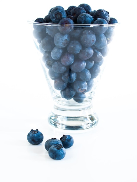 Bleuets frais du marché local sur fond blanc. Les myrtilles contiennent des anthocyanes et divers composés phytochimiques, qui peuvent jouer un rôle dans la réduction des risques de certaines maladies.