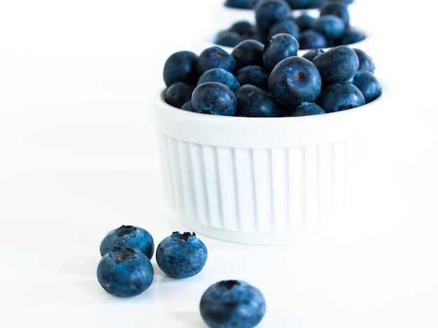 Bleuets frais du marché local sur fond blanc. Les myrtilles contiennent des anthocyanes et divers composés phytochimiques, qui peuvent jouer un rôle dans la réduction des risques de certaines maladies.