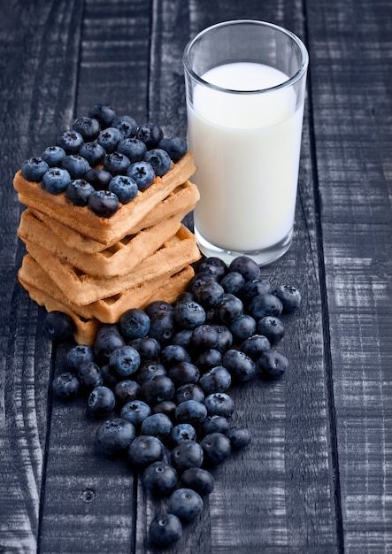 Bleuets et gaufres sur bois bleu avec verre de lait