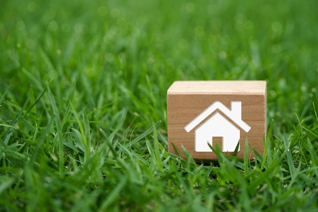 Bloc de bois avec une maison sur l'herbe