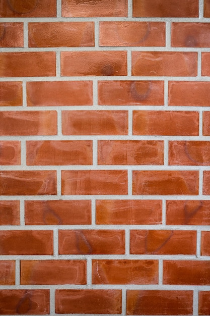 Bloc de briques orange patiné sur mur de ciment. Fond vintage et rétro