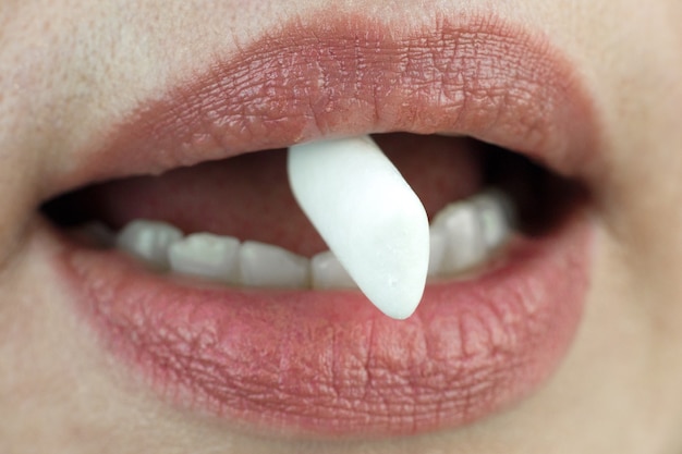 Bloc de chewing-gum entre les dents, gros plan.