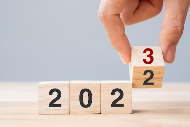 Bloc de cube à bascule à la main 2022 à 2023 texte sur la table Stratégie d'examen de la résolution Objectif de fin d'année Entreprise et concepts de vacances du Nouvel An