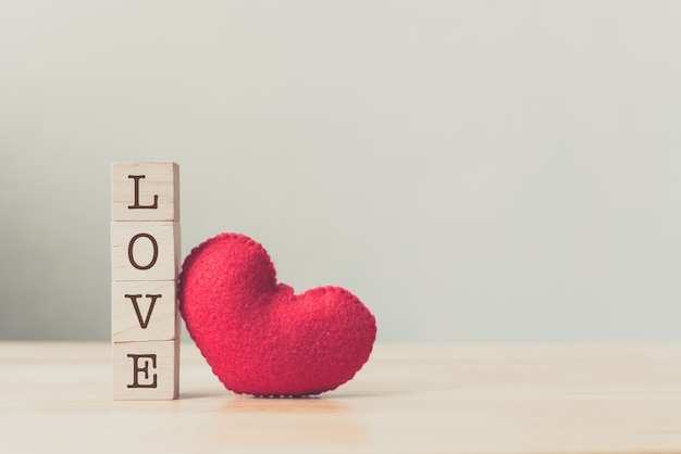 Bloc cube bois avec l&#39;amour de texte et coeur rouge sur la table en bois