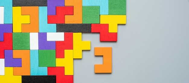 Bloc de forme géométrique avec pièce de puzzle en bois coloré.