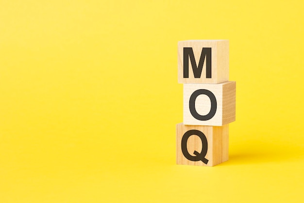 Bloc de lettres alphabétiques dans le mot MOQ Abréviation de quantité minimale de commande sur fond jaune