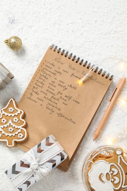 Photo bloc-notes de cookies avec liste et boîte-cadeau sur fond blanc, vue de dessus