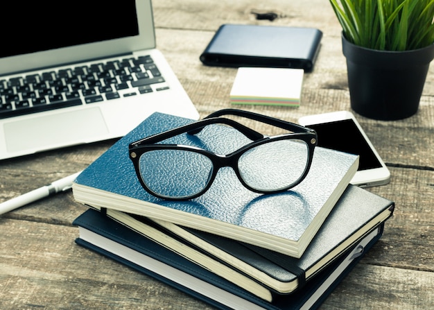 Photo bloc-notes empilés sur la table de bureau avec des lunettes