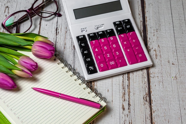 Bloc-notes de l'espace de travail et calculatrice de sphère financière au look festif tulipes et lunettes pour femmes sur fond de bois