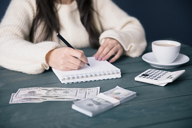 Bloc-notes de main de femme avec de l'argent