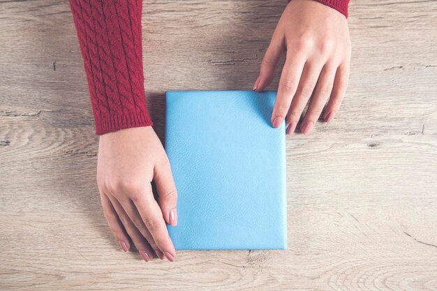 Bloc-notes de main de femme sur le bureau