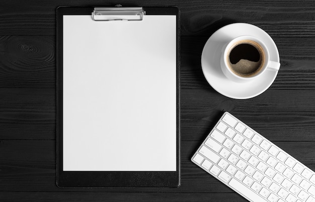 Le bloc-notes ouvert blanc et clavier d&#39;ordinateur, souris, mobile, café isolé sur le bureau en bois