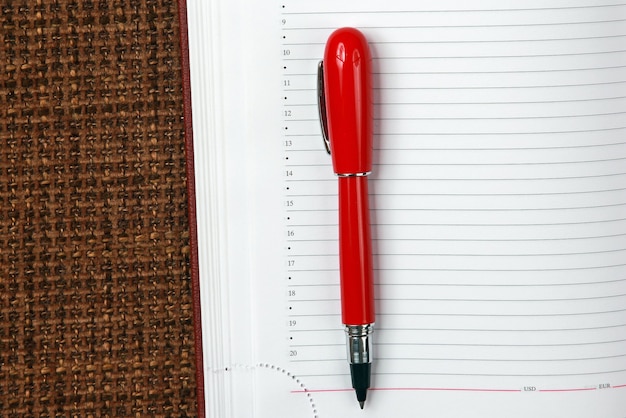 Photo bloc-notes ouvert et gros plan stylo rouge