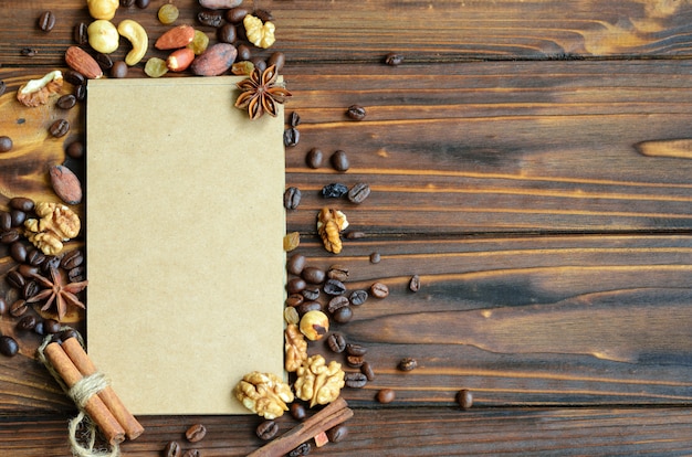 Bloc-notes avec des pages en papier kraft entourées d&#39;un cadre de grains de café, de raisins secs et de noix