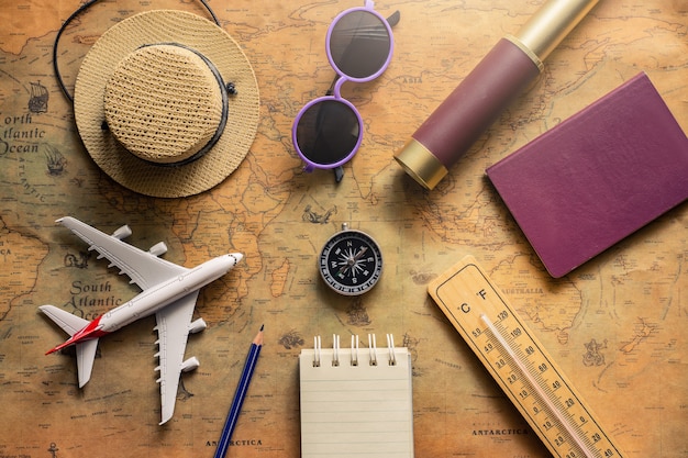 Bloc-notes pour note avec passeport, jumelles, crayon, boussole, avion sur carte papier pour image de voyage aventure découverte