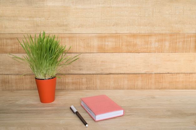 Bloc-notes et stylo sur la table en bois. Plante d'intérieur verte