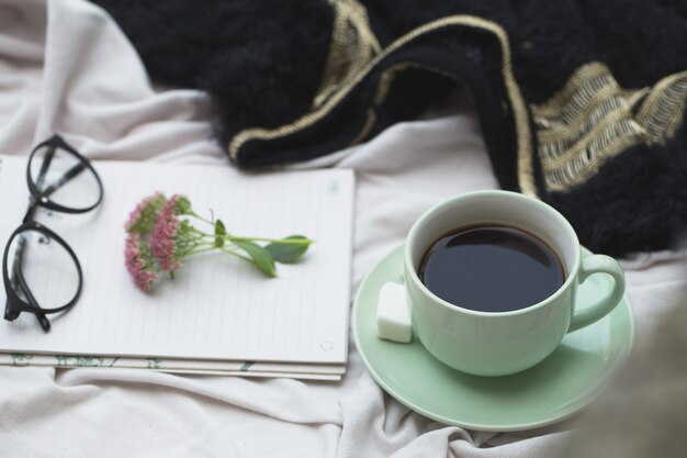 Bloc-notes et tasse de café sur bois.