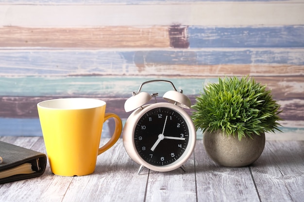 Photo bloc-notes de tasse de café et horloge sur la table se bouchent